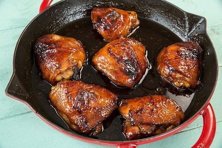 Six pieces of honey garlic chicken in a cast iron skillet