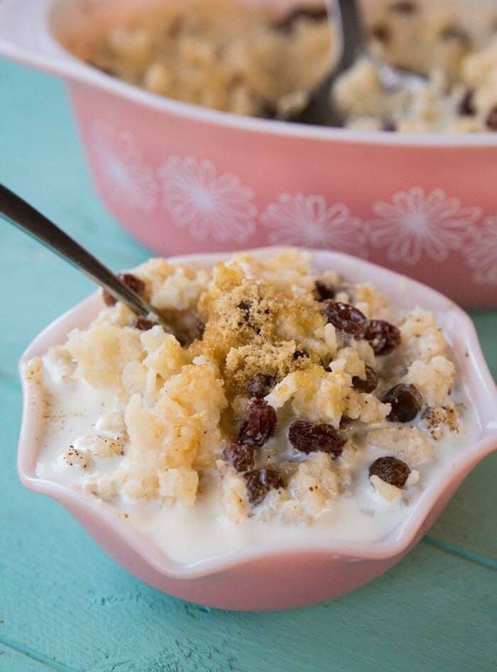 Baked Rice Pudding with sugar in a pink bowl with a spoon