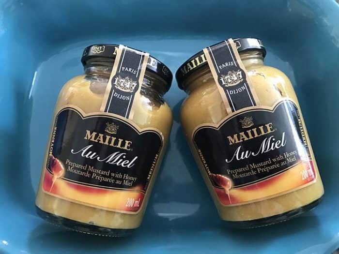 two bottles of Maille Mustard in a blue container