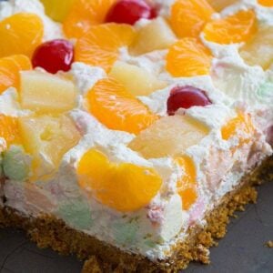 Close up of Ambrosia Salad Squares Topped with Mandarin Slices, Pineapple Chunks and Maraschino Cherries