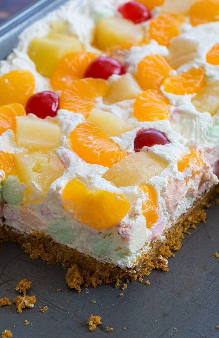 Close up of Ambrosia Salad Squares Topped with Mandarin Slices, Pineapple Chunks and Maraschino Cherries