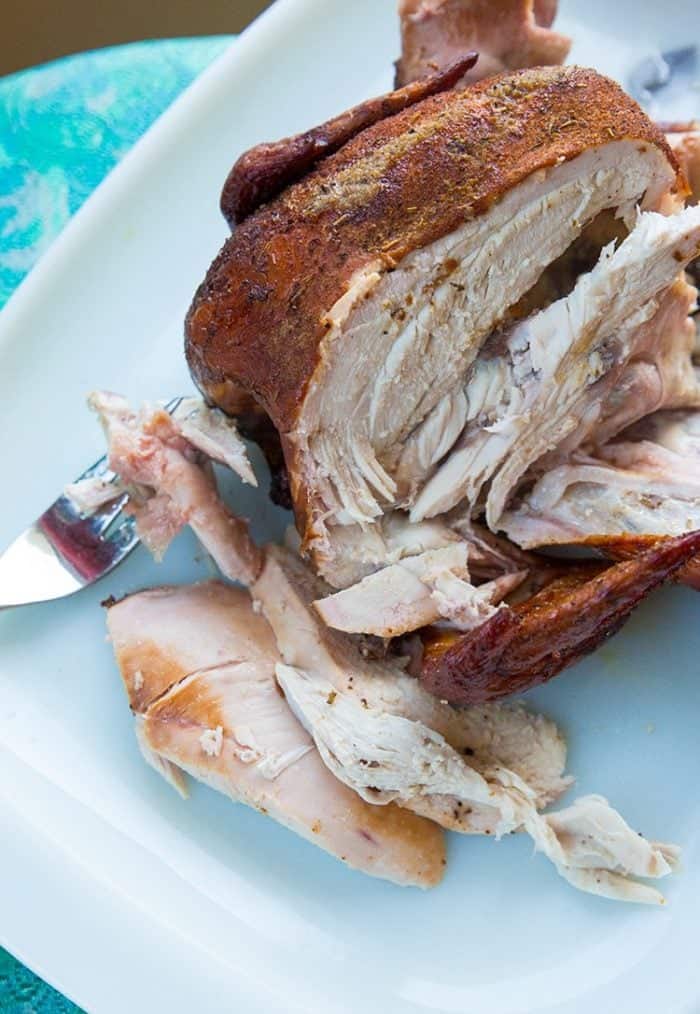 Beer Can Chicken on a white plate showing the inside of chicken