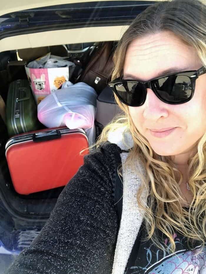 a lady taking self picture with the baggages in her background