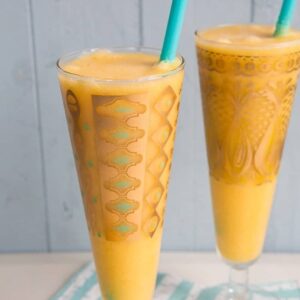 Close up Glasses of Mango Margarita with jade blue straws