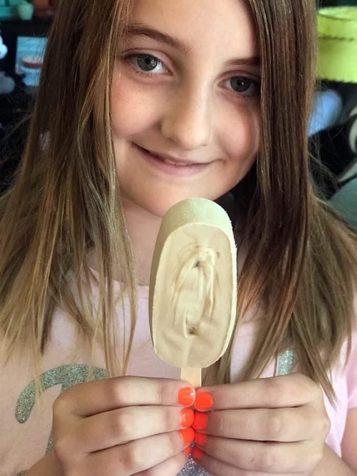 girl smiling while holding a Maple-Flavoured Ice Cream Bar