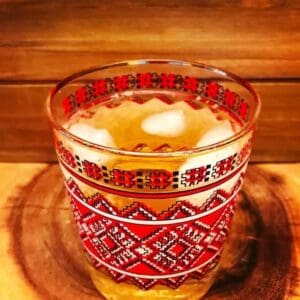 A glass of Stonewall Whisky Cocktail on red wood background