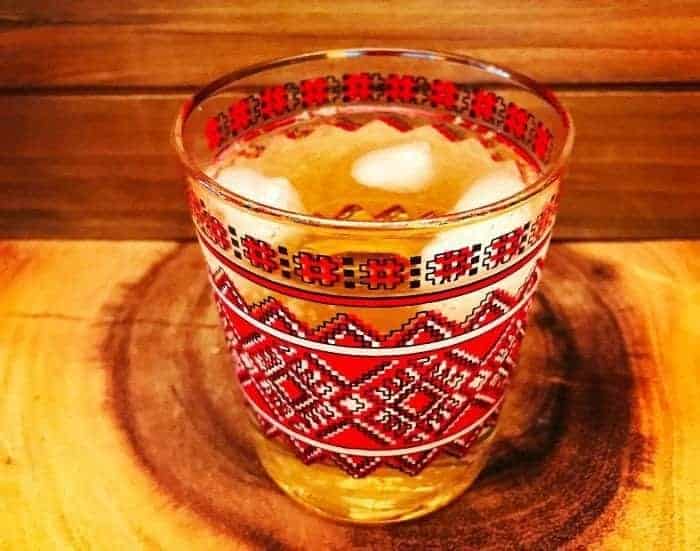 A glass of Stonewall Whisky Cocktail on red wood background