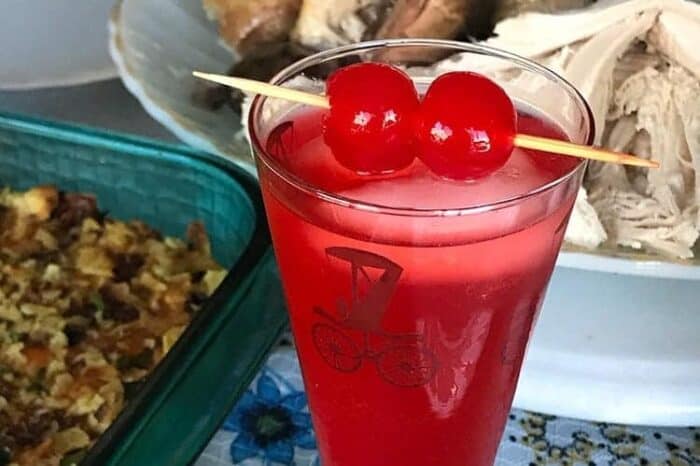 American Fizz Cocktail in a vintage automotive motif glass garnish with cherries in pick