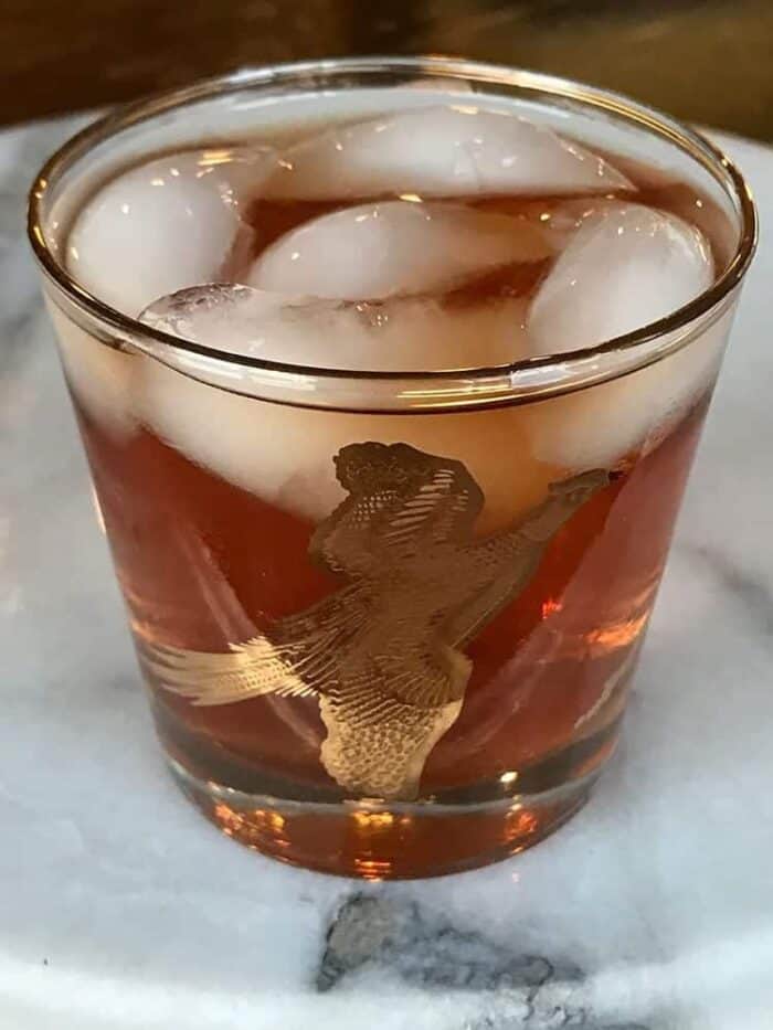 vintage bird glass with ice and Mickie Walker Cocktail on marble background