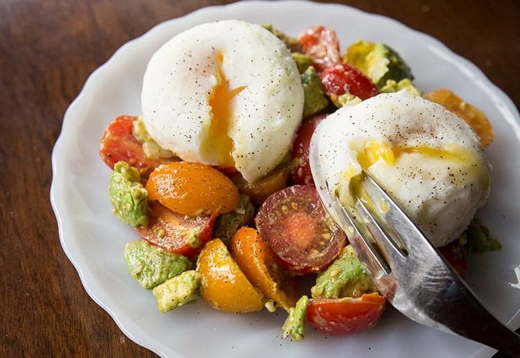 Pesto Tomato, Egg & Avocado Breakfast Salad in a white plate