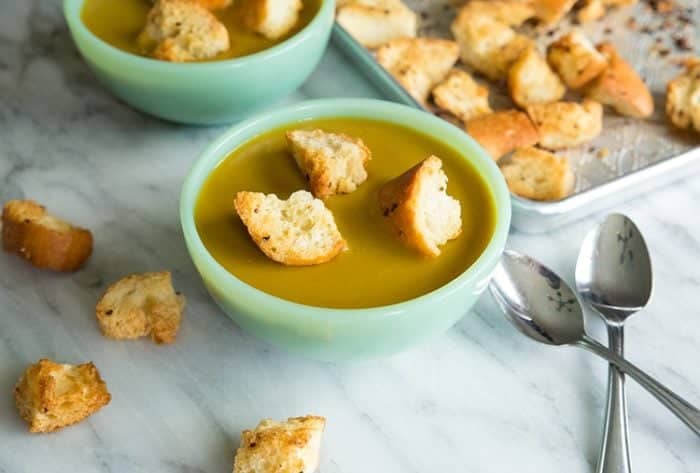 Vegan Curried Split Pea Soup with Homemade Garlic Croutons on a marble background