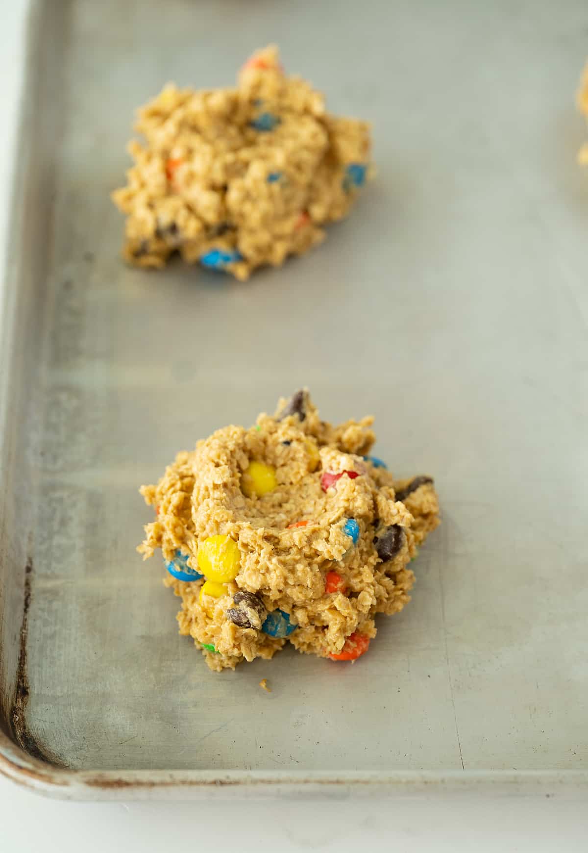 large scoop of monster cookie batter in baking sheet