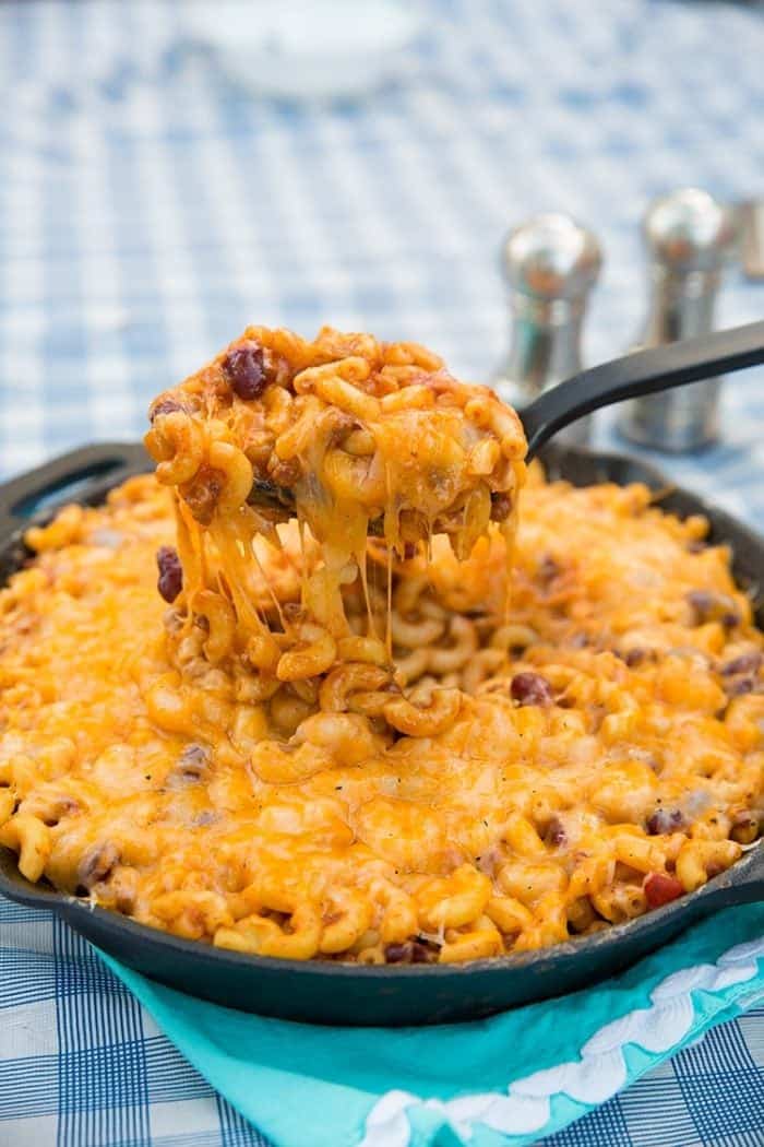 close up of a spoon full of cheesy chili mac skillet 