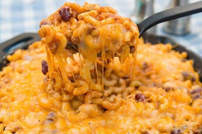 close up of a spoon full of cheesy chili mac skillet