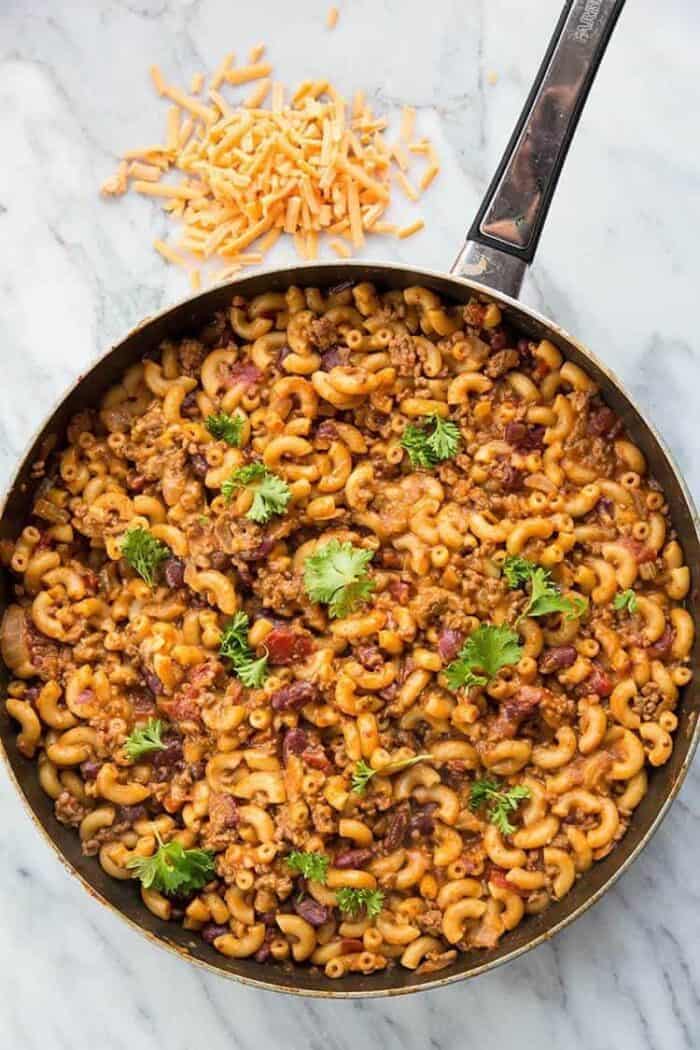 top down shot of Homemade Cheesy Chili Mac Skillet in marble background