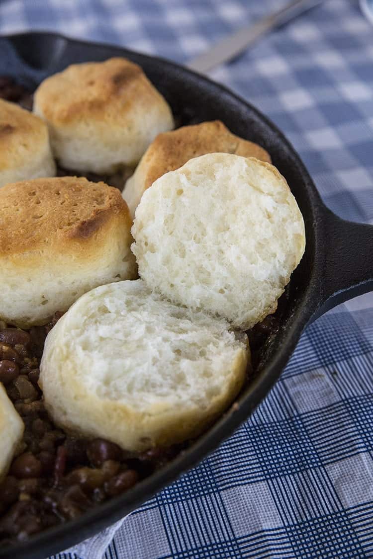 Close up Pork & Beans Cowboy Casserole iron skillet with biscuits on top