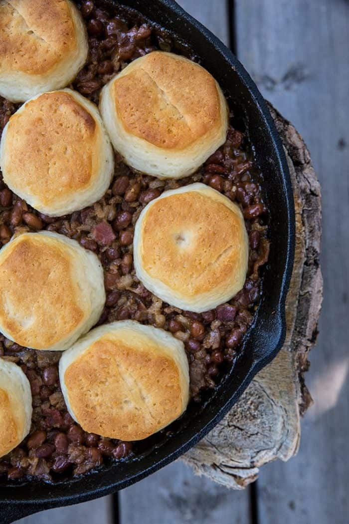 Pork & Beans Cowboy Casserole in a cast iron skillet with biscuits on top