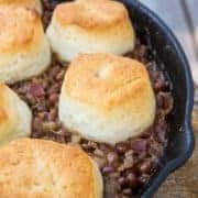 Close up Pork & Beans Cowboy Casserole iron skillet with biscuits on top