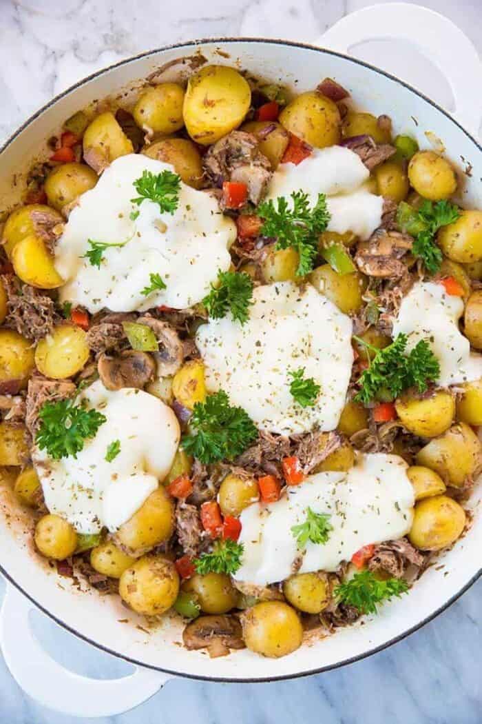 top down shot of Cheesy Italian Beef Breakfast Skillet in a marble background