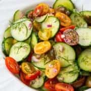 Cucumber Salad with Tomato and Dill in a large white serving bowl