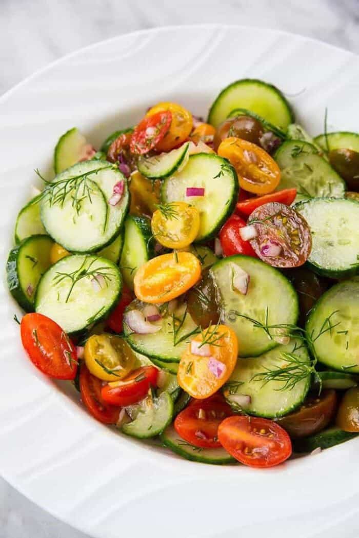 Cucumber Salad with Tomato and Dill in a large white serving bowl