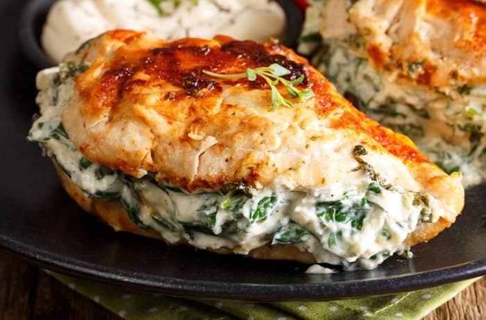 Pan Fried Spinach & Cream Cheese Stuffed Chicken Breasts in a black plate