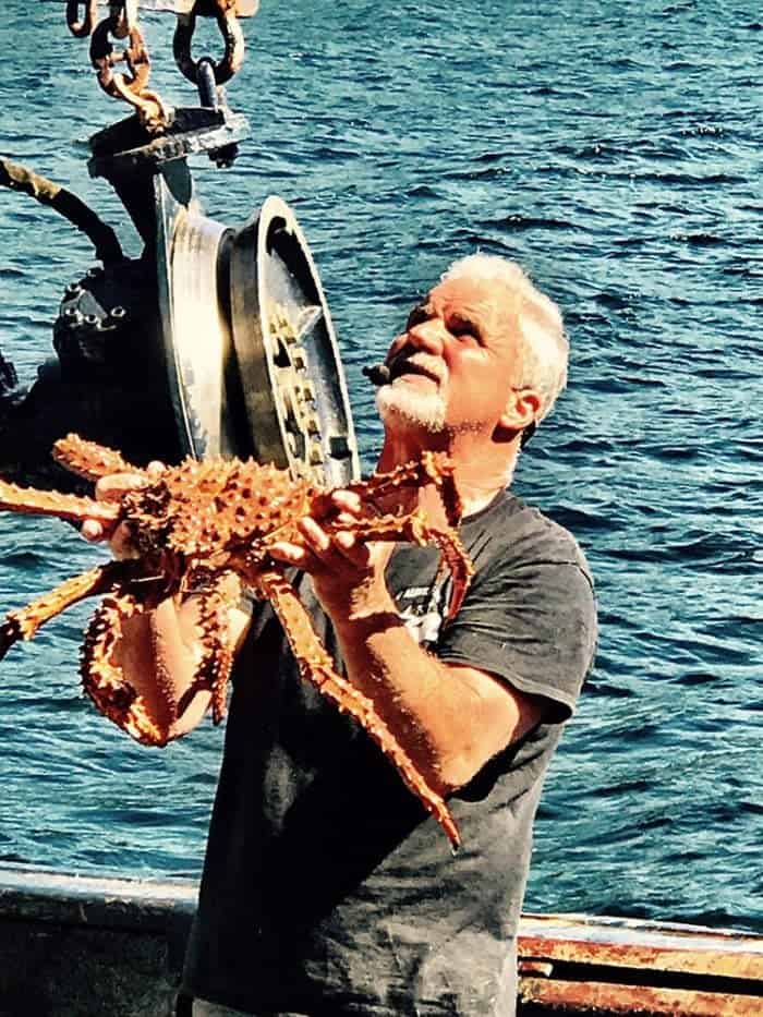 crab pot pulled out, a man holding a large crab