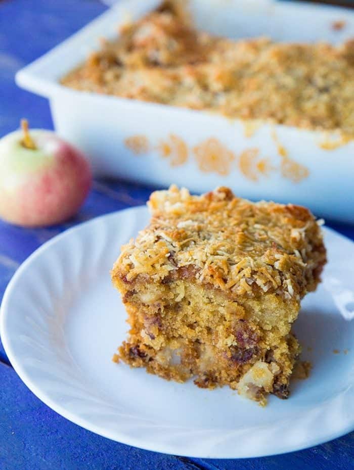 close up Australian Lumberjack Cake on a plate and on a baking dish with an apple on the side