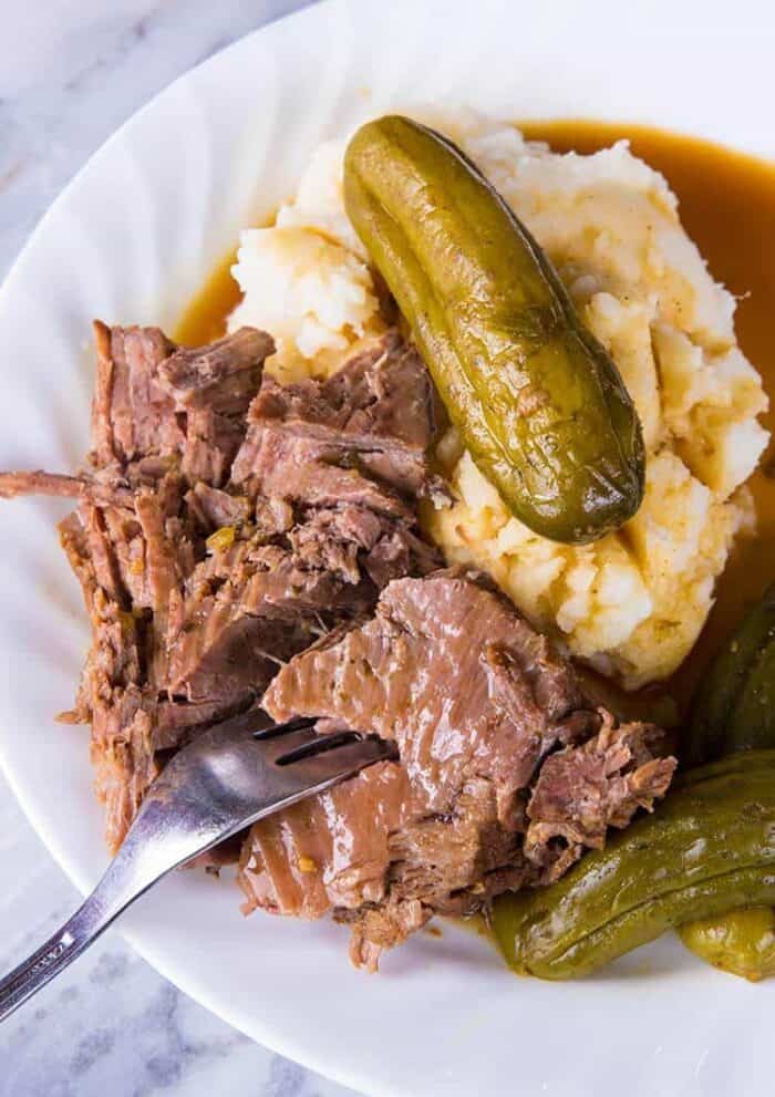 Dill pickle Beef instant pot dinner served with mashed potatoes on a white plate