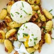 top down shot of Gnocchi Breakfast Skillet with bacon, green onions and top with eggs