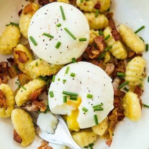 top down shot of Gnocchi Breakfast Skillet with bacon, green onions and top with eggs