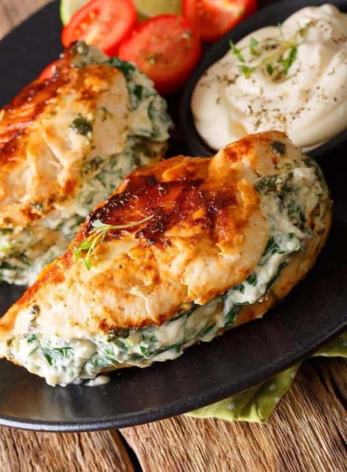 close up Pan Fried Stuffed Chicken Breasts with Spinach & Cream Cheese in a black serving plate