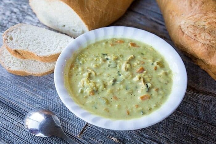 Cream of Chicken & Wild Rice Soup in a white bowl, slices of crusty loaf French bread on background