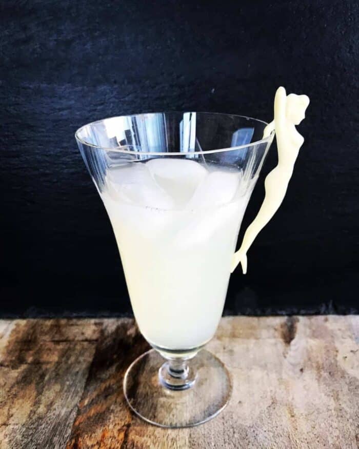 a glass of Honeysuckle Cocktail with a white vintage party girl fork on side