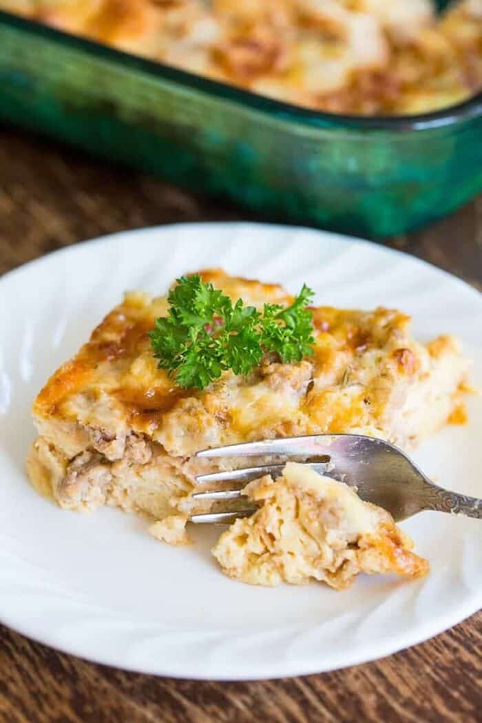 a slice of Breakfast Casserole in a white plate, Pyrex baking pan on background