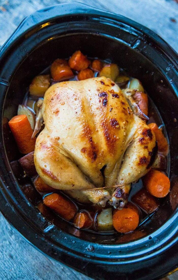 Roast a whole chicken in your crockpot with a delicious honey garlic sauce & vegetables