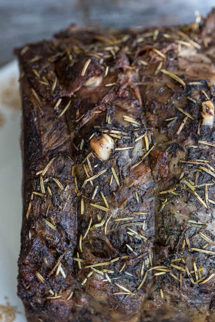 close up roast covered with butter and herb
