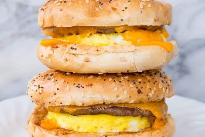 close up Sausage & Egg Breakfast Bagels in a white plate on a marble background