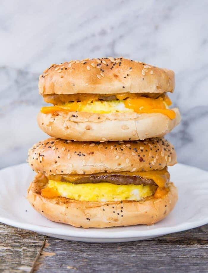 close up Sausage & Egg Breakfast Bagels in a white plate on a marble background