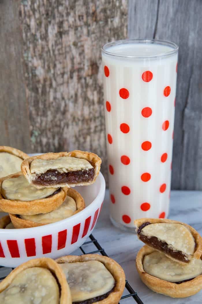 a bowl of mincemeat tarts and a tall glass of milk ready to enjoy!