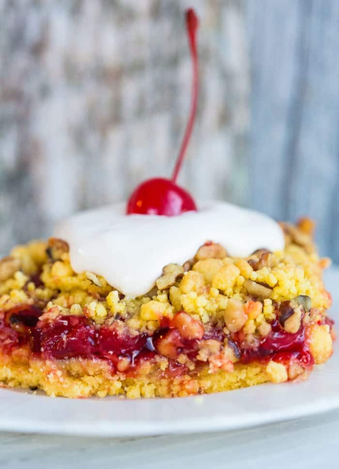  Close up of a Lemon Cherry Crunch Cake on a white plate