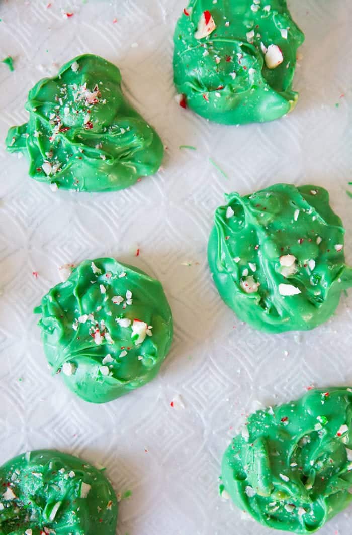 Minty Grinch Candy sprinkled with broken candy cane on white background