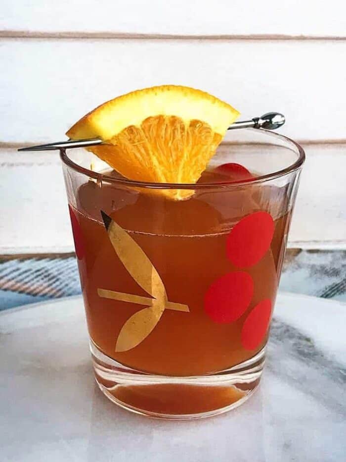 Alabama Slammer Cocktail in Cherries vintage glass garnish with a small slice of orange