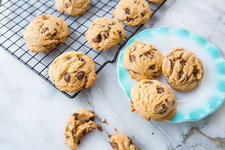 Chocolate chip cookies on black cooling rack and on plate. Recipe without baking soda or baking powder.