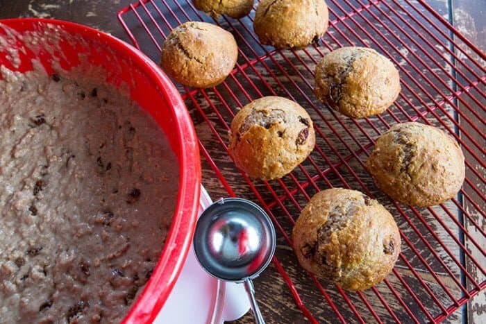 Cinnamon Raisin Oat Bran Mixture in Red Bowl and Muffins in red cooling rack