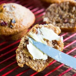 Adding Spread to Half Sliced Oat Bran Muffins on Red Cooling Rack