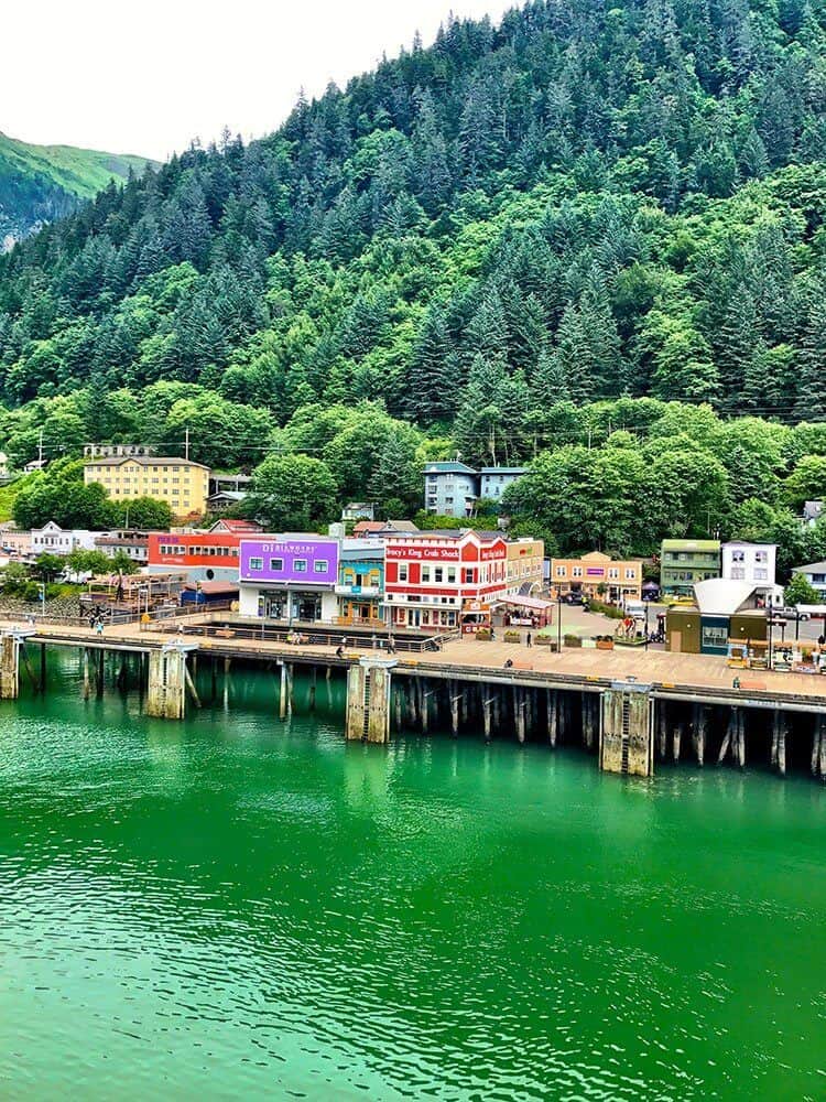 Juneau port with a view of colorful establishments and high pine trees