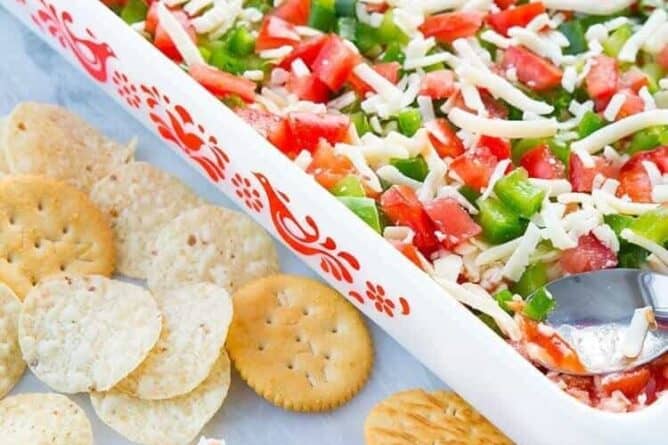 Shrimp Dip in white Pyrex baking pan and in chips and crackers