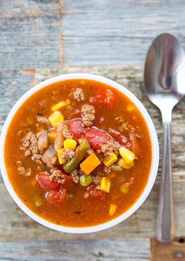 Top down shot of Simple Classic Hamburger Soup in a bowl with a spoon on the side of the bowl