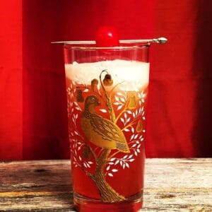 Singapore Sling in a vintage partridge in a pear tree glasses garnish with cherry on pick
